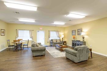 A living room with a grey sofa, a wooden table and a fireplace at Robinson Park Apartments, Harrisonburg, VA